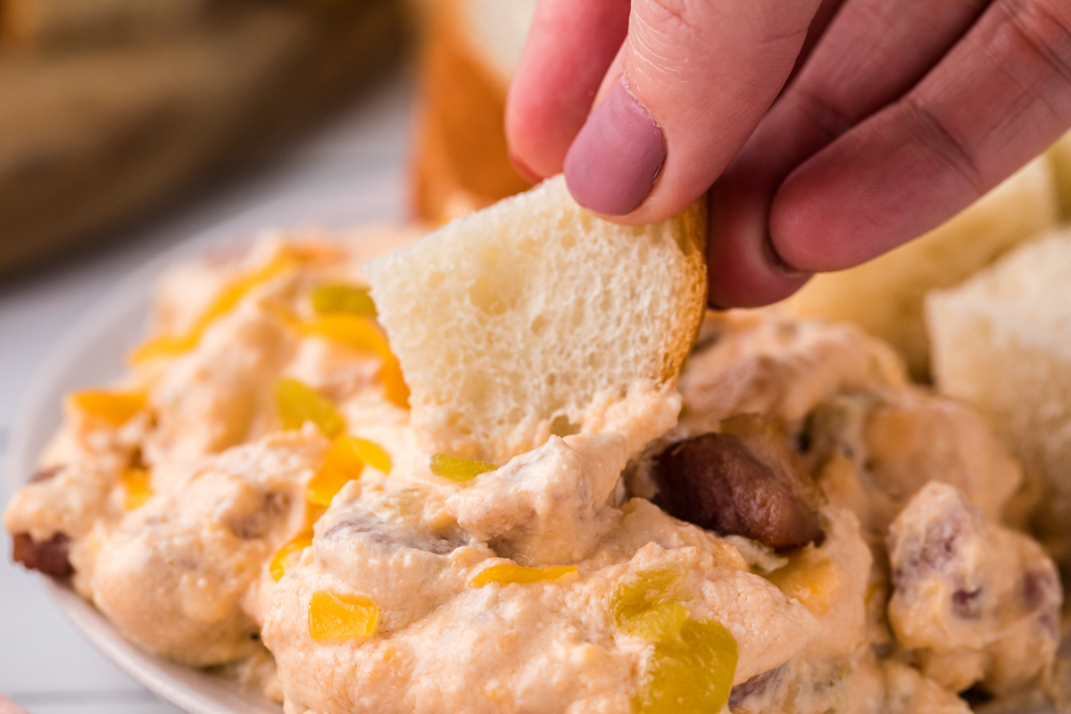 close up of bread being dipped into mississipi sin dip.