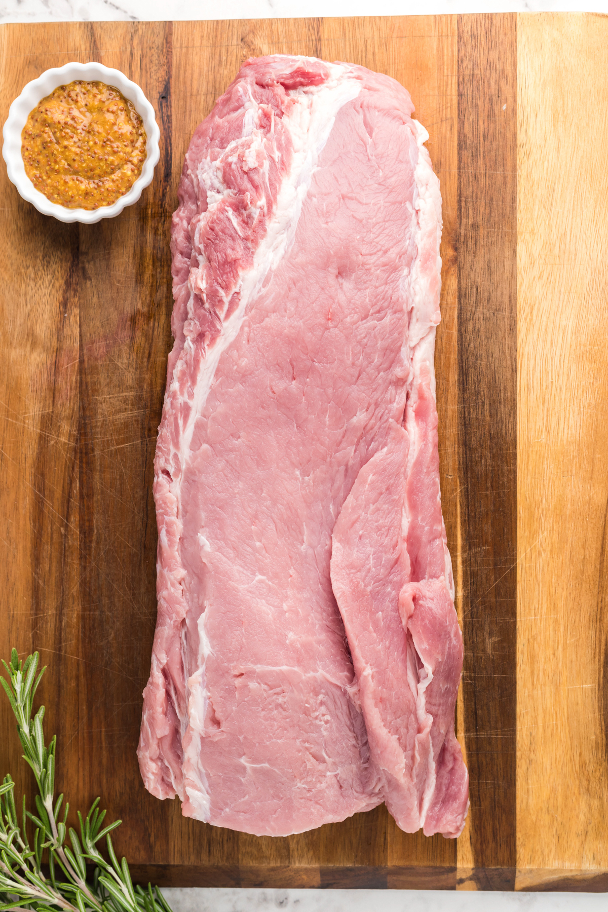 overhead of raw pork loan on a wooden board.
