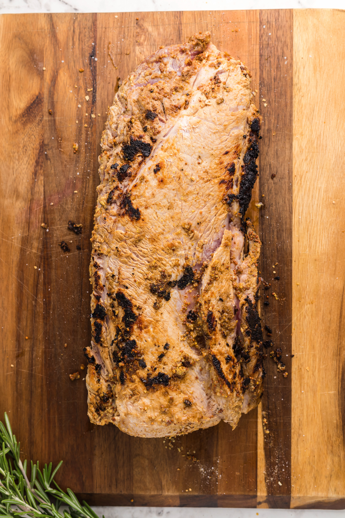 overhead of seared pork loin on a wooden board.
