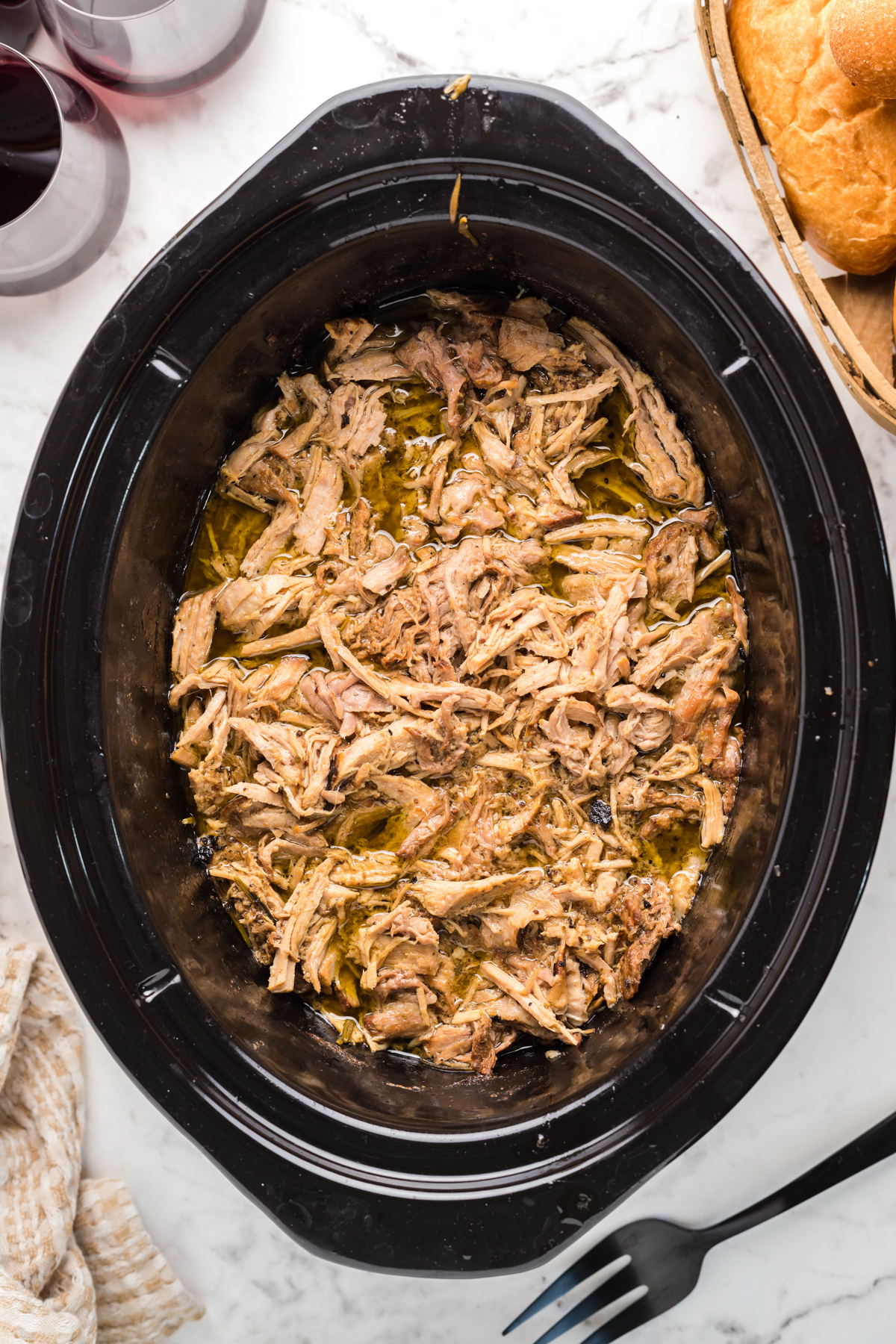 overhead of pulled pork in slow cooker after shredding the cooked meat.