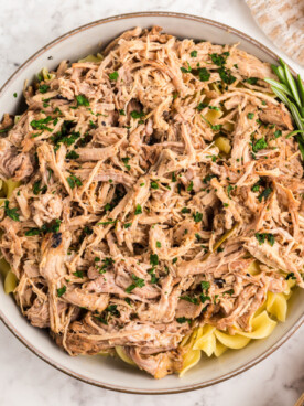 overhead of slow cooker pulled pork pasta in a serving bowl.