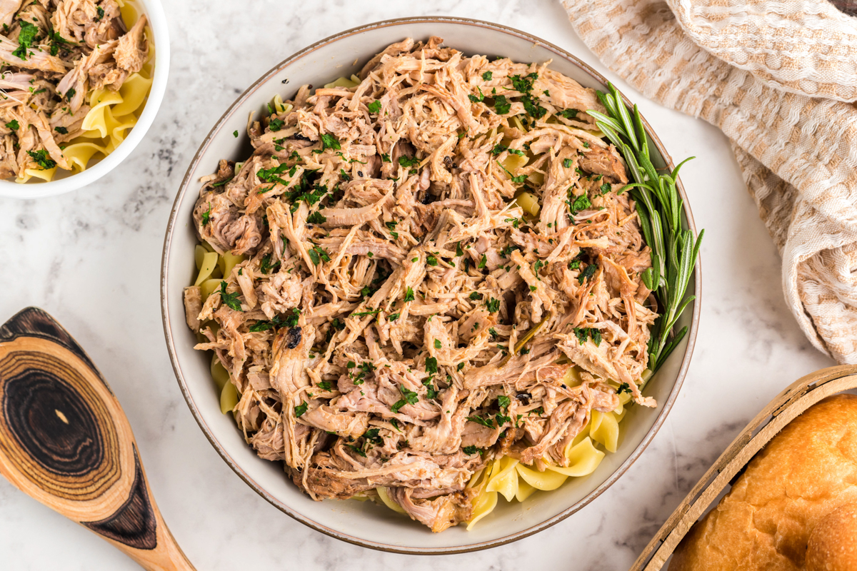 overhead of slow cooker pulled pork pasta in a serving bowl.