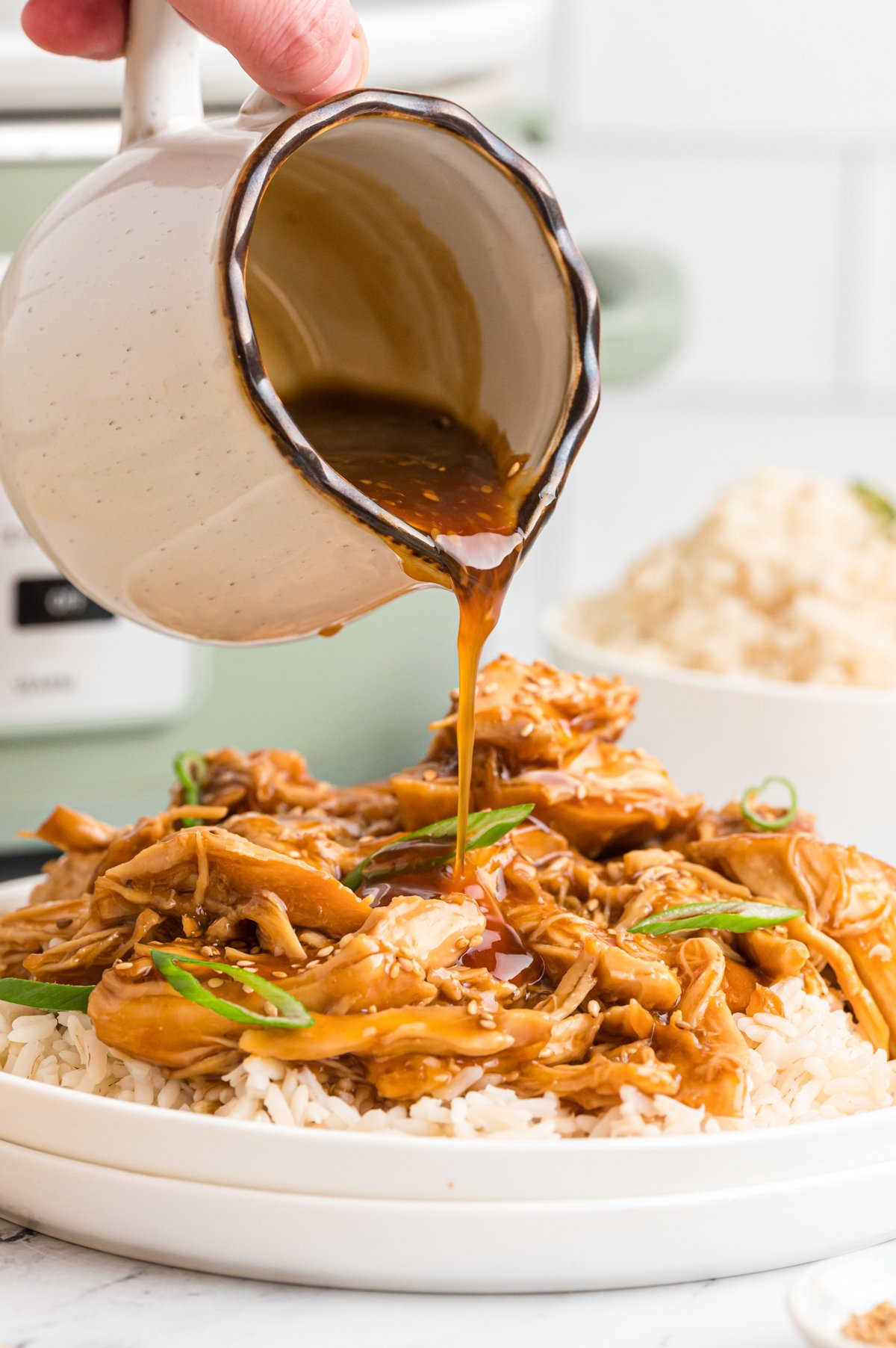 teriyaki sauce being pour over chicken.