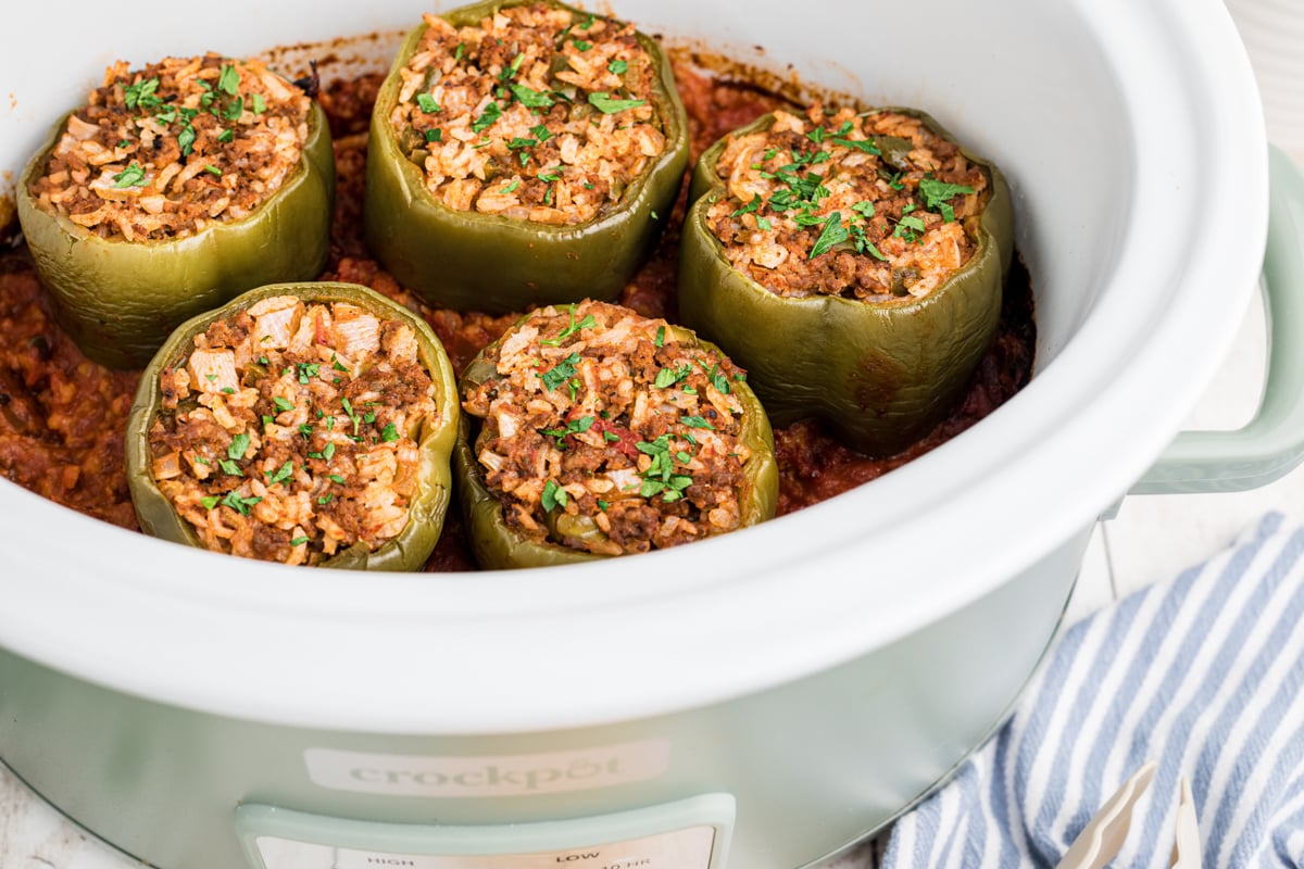 beef stuffed peppers in a white slow cooker.