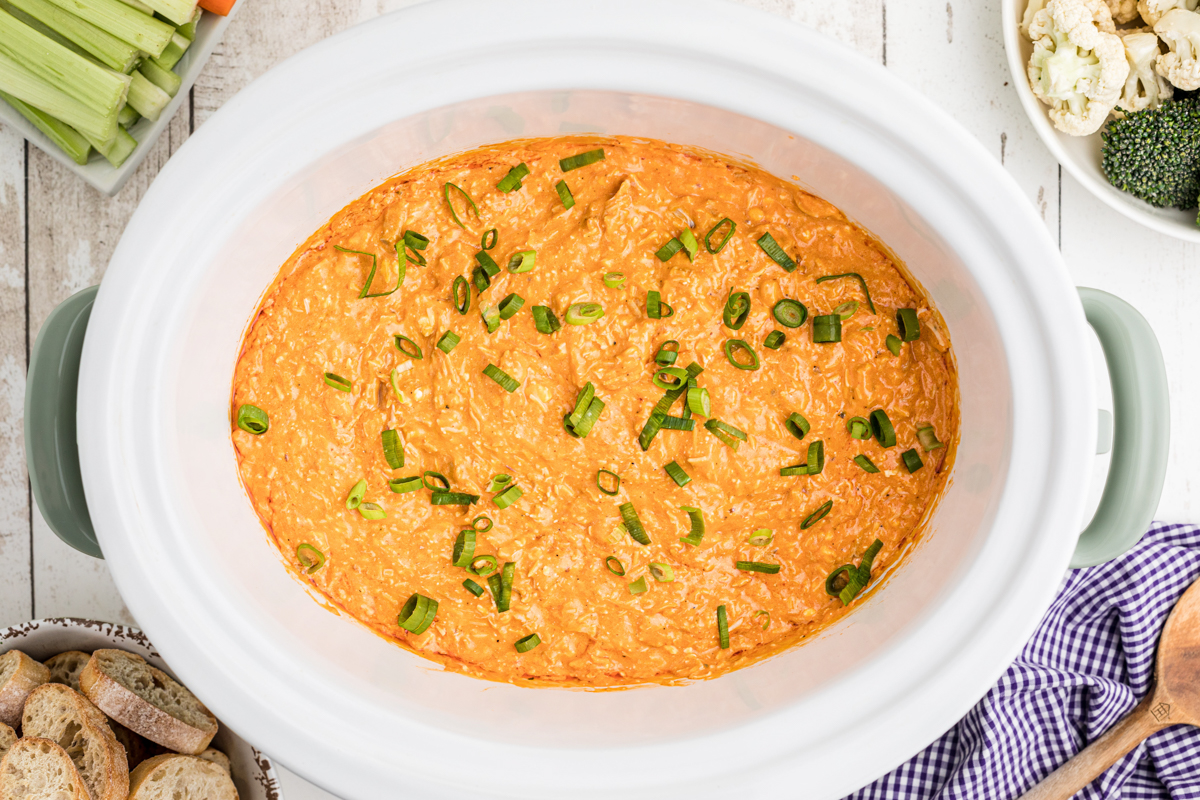 overhead shot of buffalo dip with green onions on top.