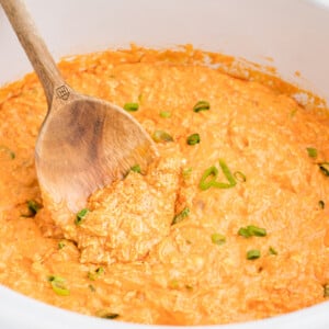 buffalo dip with a wooden spoon in it.