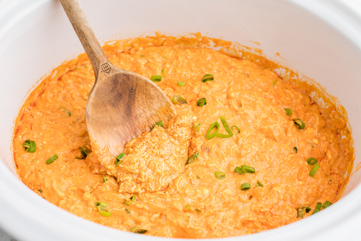 buffalo dip with a wooden spoon in it.