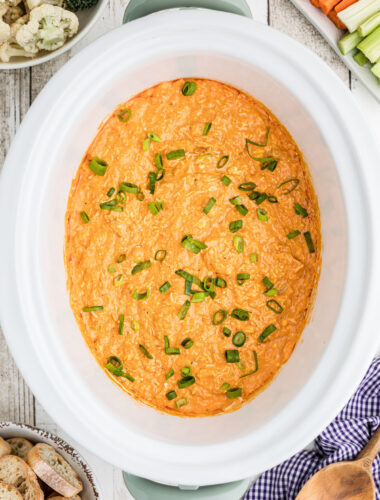 Buffalo chicken dip with green onions on top.