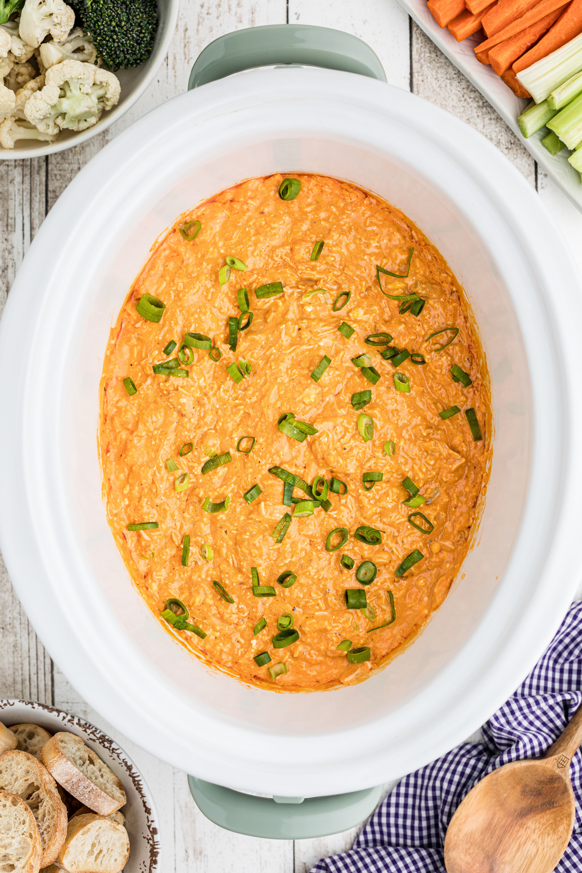 Buffalo chicken dip with green onions on top.