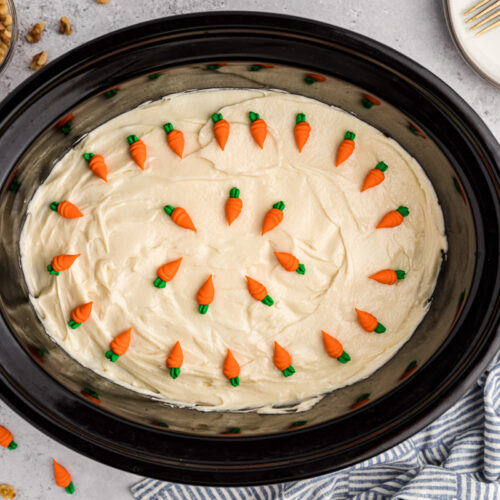 Carrot cake in the slow cooker with carrot decorations on top.