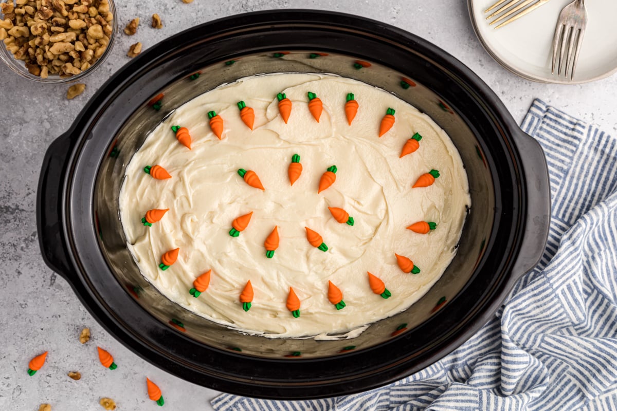 Carrot cake in the slow cooker with carrot decorations on top.