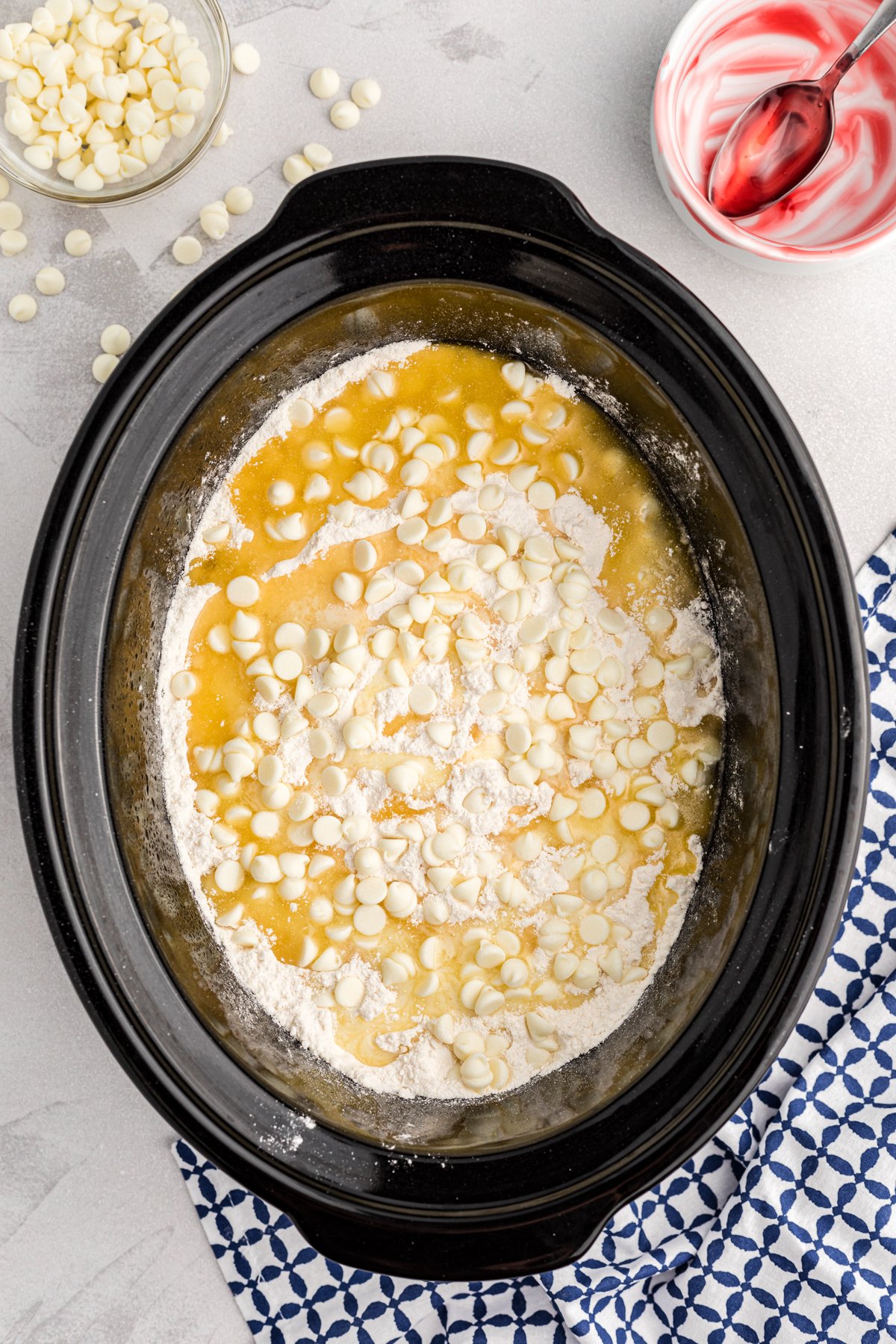 cake mix, butter and white chocolate chips on cherry pie filling in a crockpot.