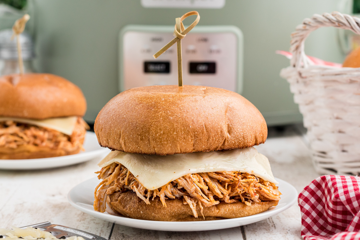 chicken sandwiches on plates in a slow cooker.