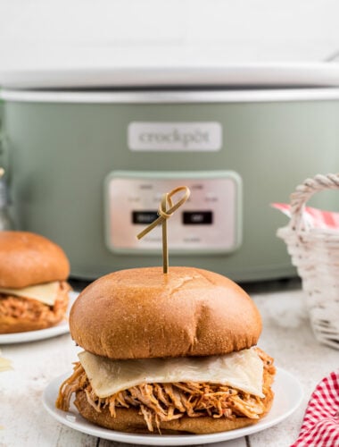 Chicken sandwich sitting in front of a slow cooker.