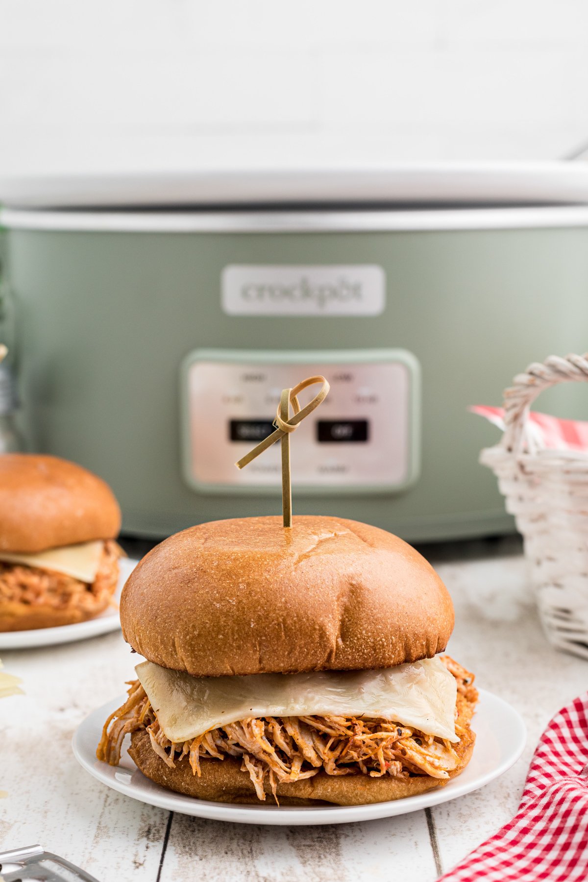 Chicken sandwich sitting in front of a slow cooker.