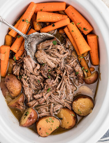 Pot roast with vegetables and coca cola in a slow cooker.