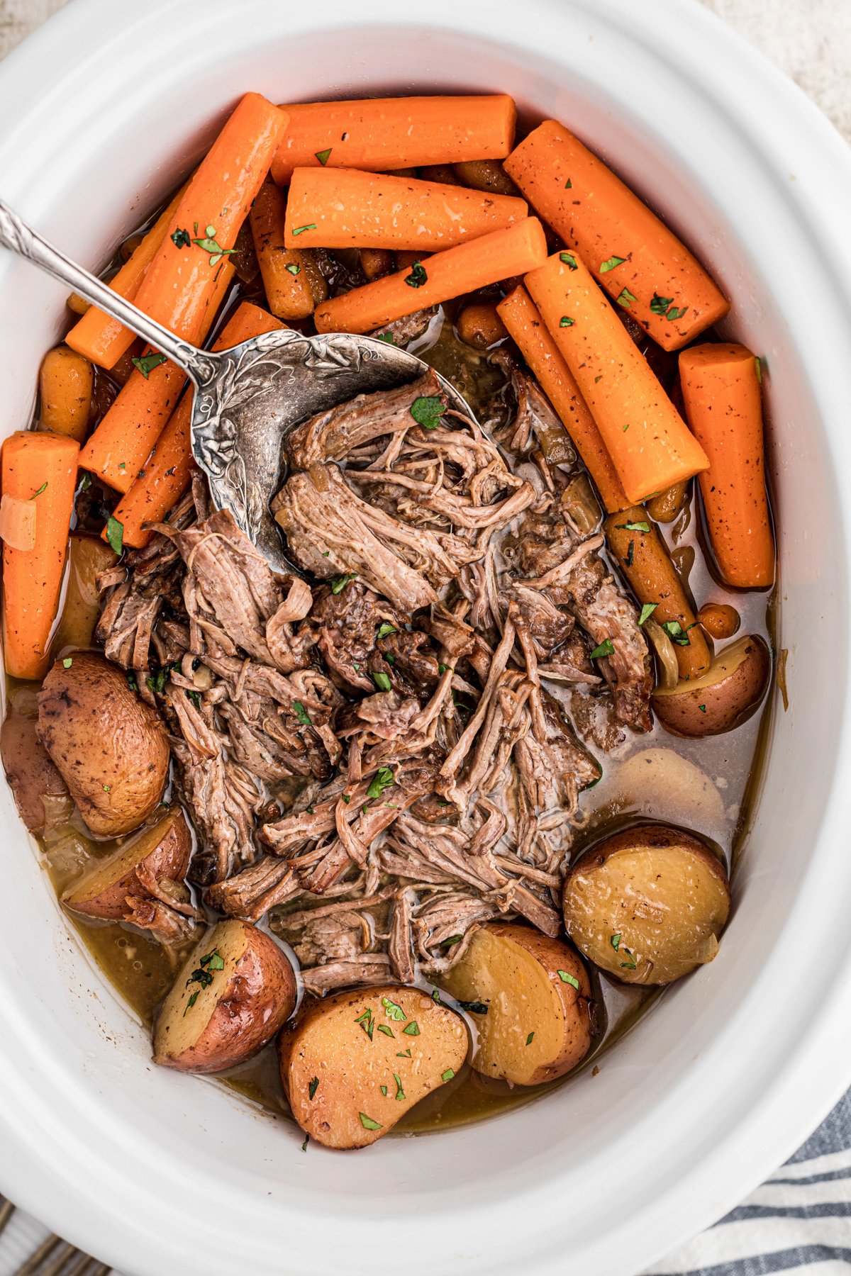 Pot roast with vegetables and coca cola in a slow cooker.