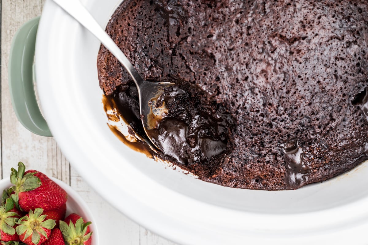 lave cake in crock pot with a spoonful taken out.