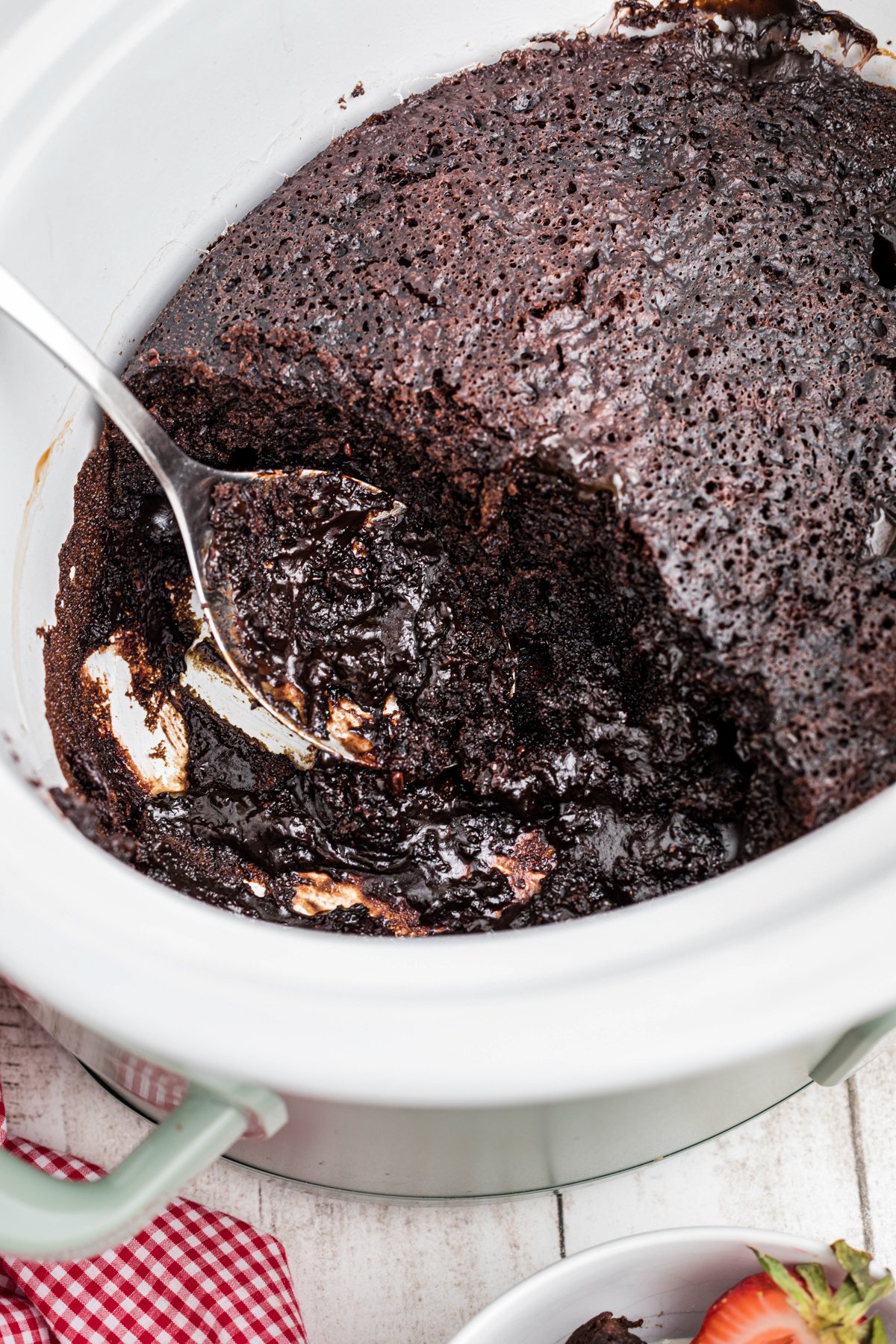 lava cake in a slow cooker with a metal spoon in it.