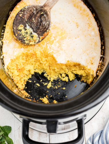 lemon cake in a slow cooker with a spoon on top.