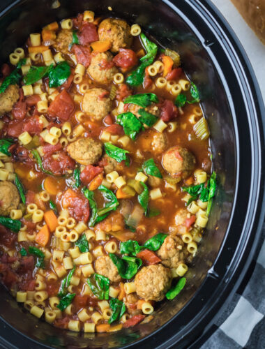 close up of meatball soup in a black crockpot.