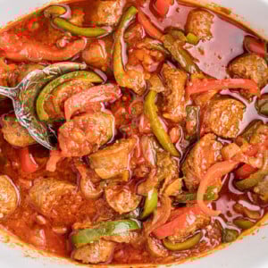 overhead shot of sausage and peppers in a slow cooker.