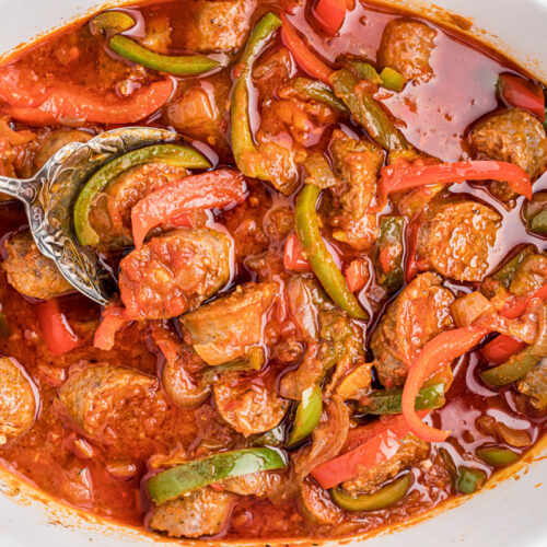 overhead shot of sausage and peppers in a slow cooker.