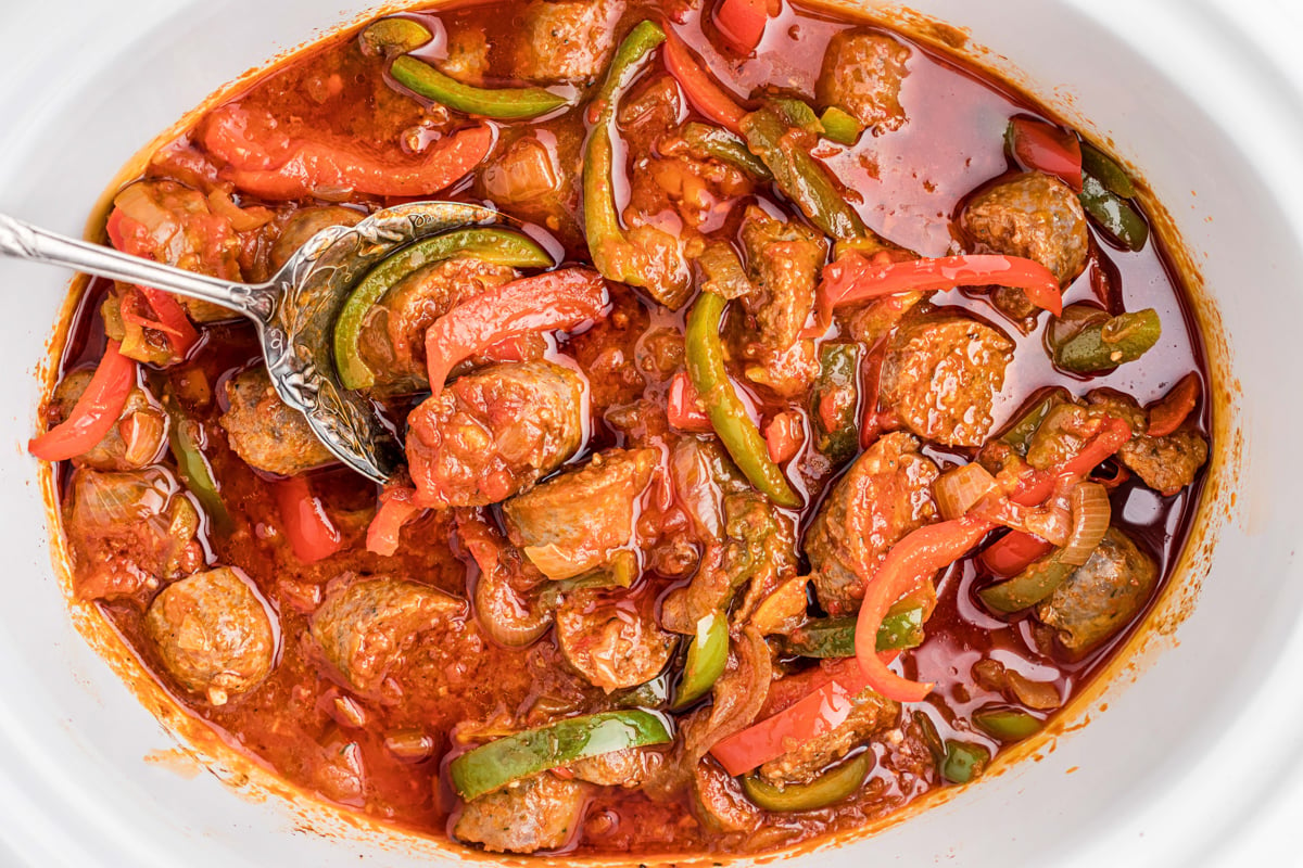 overhead shot of sausage and peppers in a slow cooker.