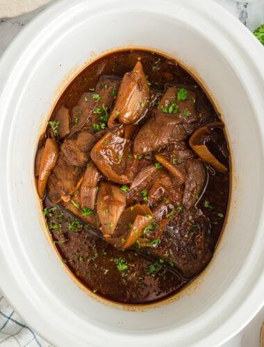 Beef brisket with onions and barbecue sauce in a slow cooker.