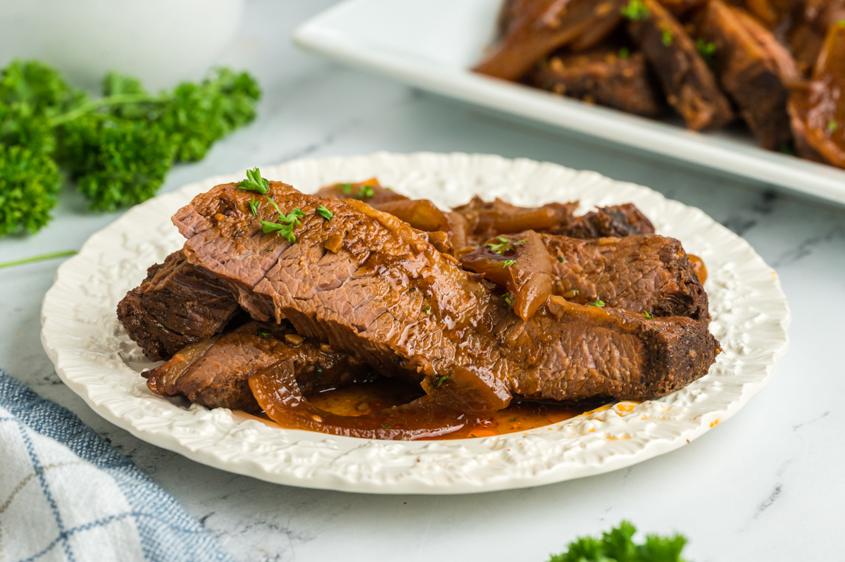 plate of beef brisket with onions and barbecue sauce.