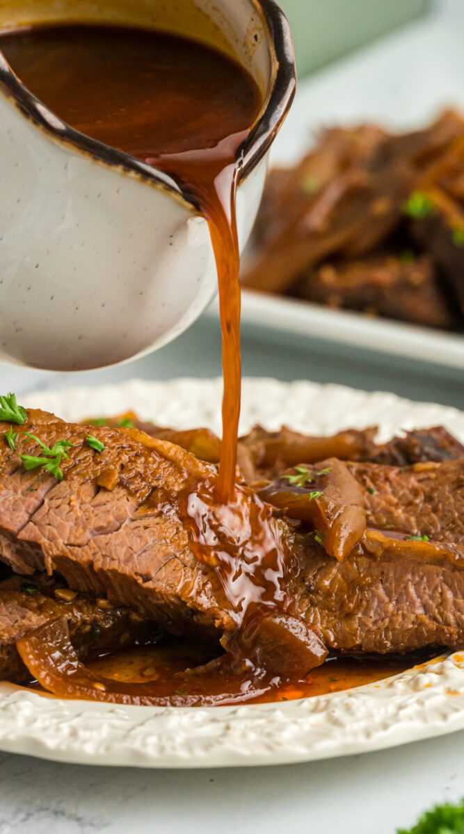 liquid being poured over beef brisket.