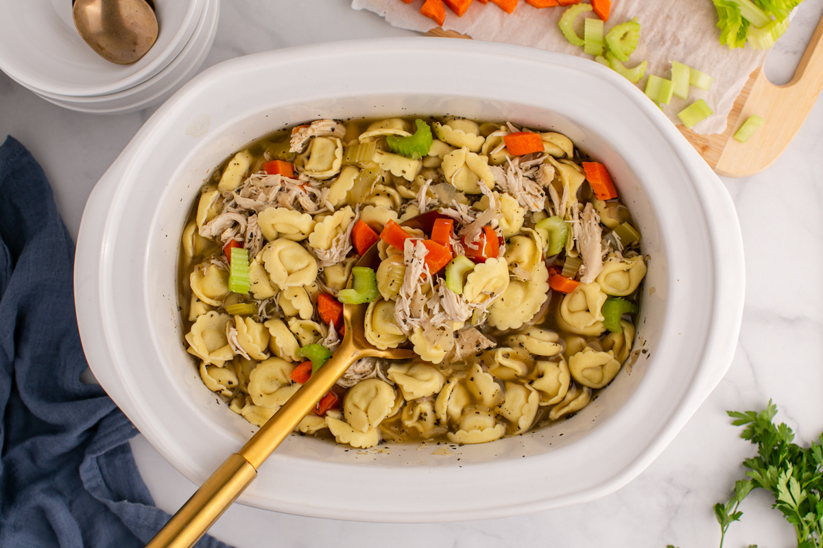 Overhead shot of cooked chicken soup with tortellini.