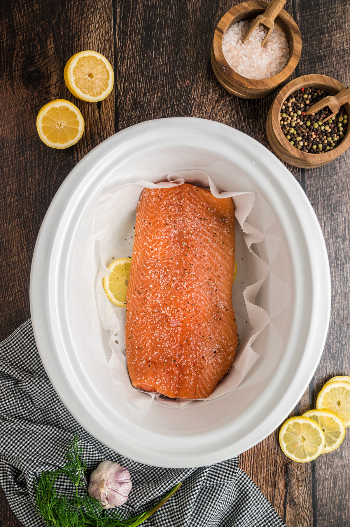 salmon and seasonings on top of the lemons.