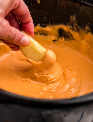 apple being dipped into cheese fondue.