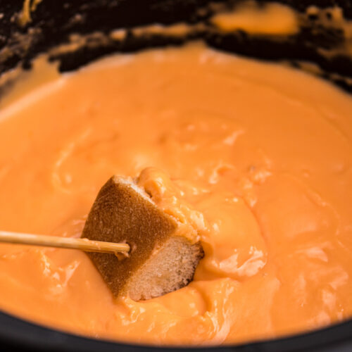 Fondue in a crockpot with bread.