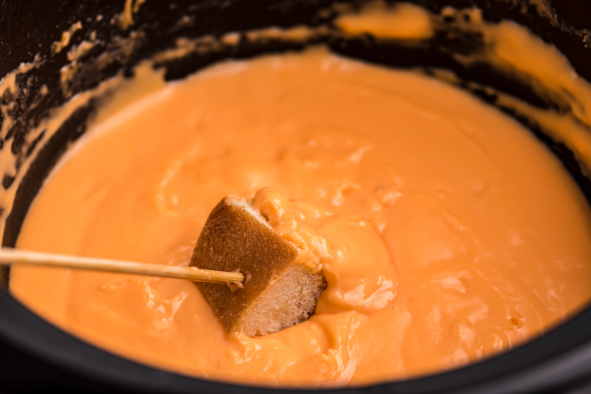 Fondue in a crockpot with bread.