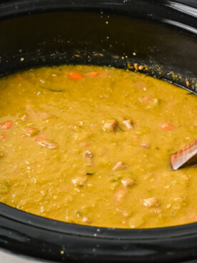 side view of split pea soup in a crockpot, done cooking.