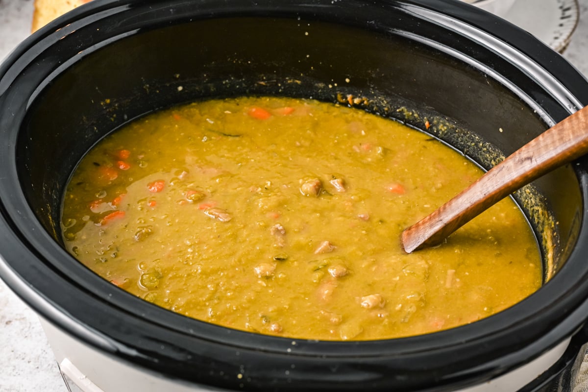 side view of split pea soup in a crockpot, done cooking.