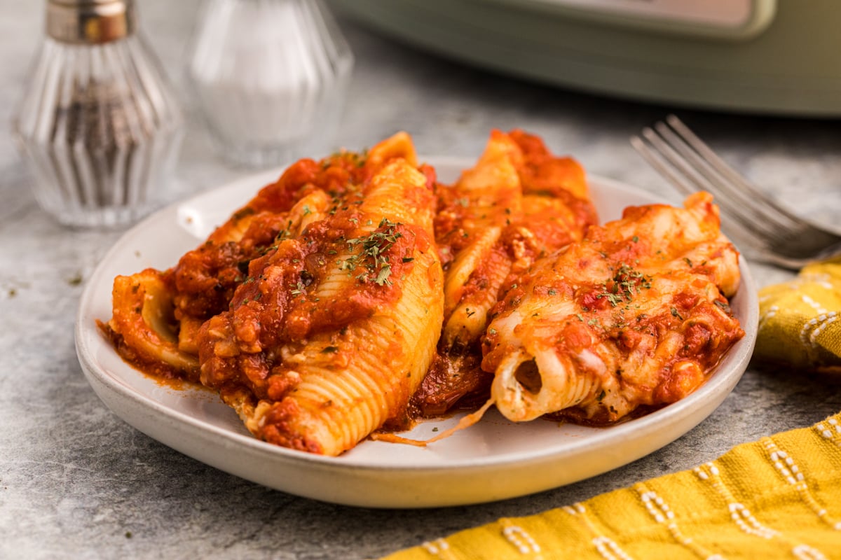 plate of stuffed shells in front of a slow cooker.