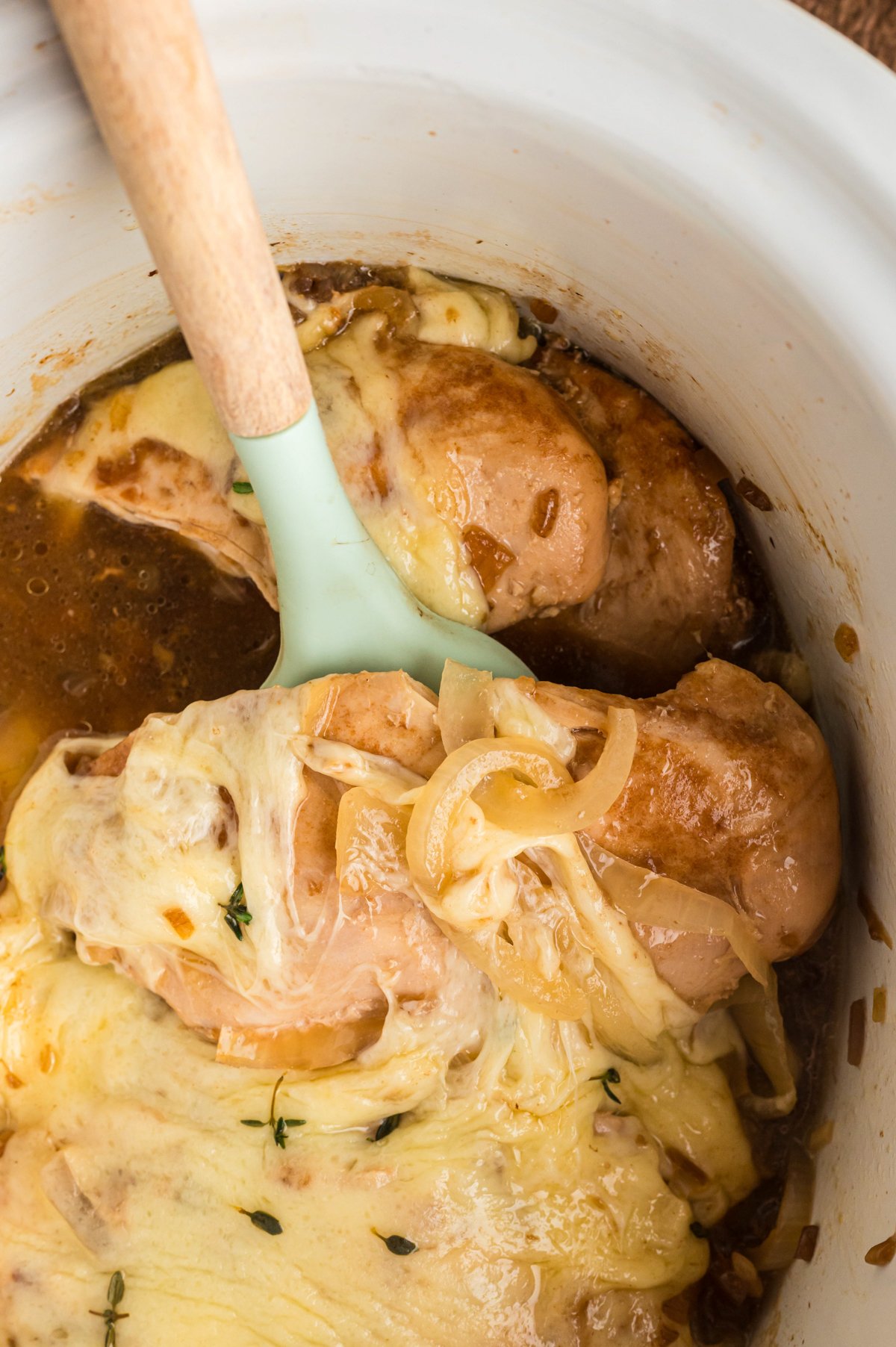 close up of french onion chicken on a spatula.