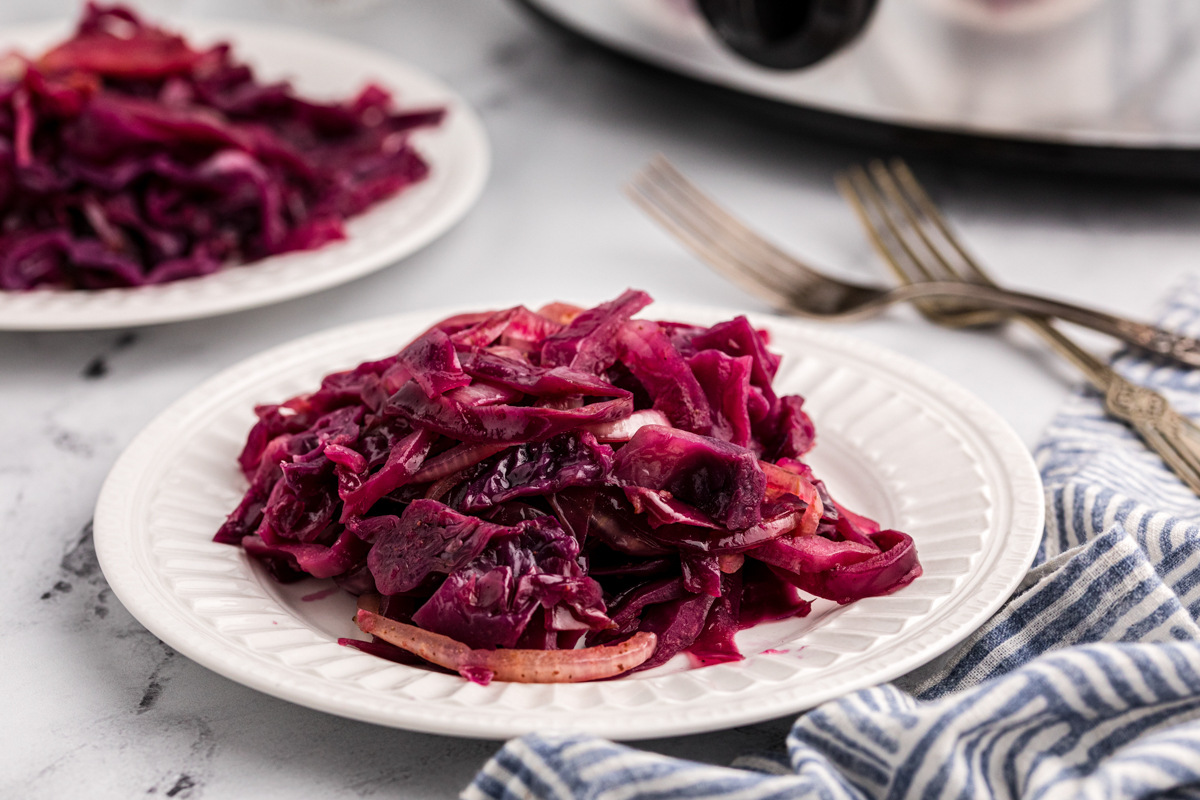 Red cabbage on a plate in front of a slow cooker.
