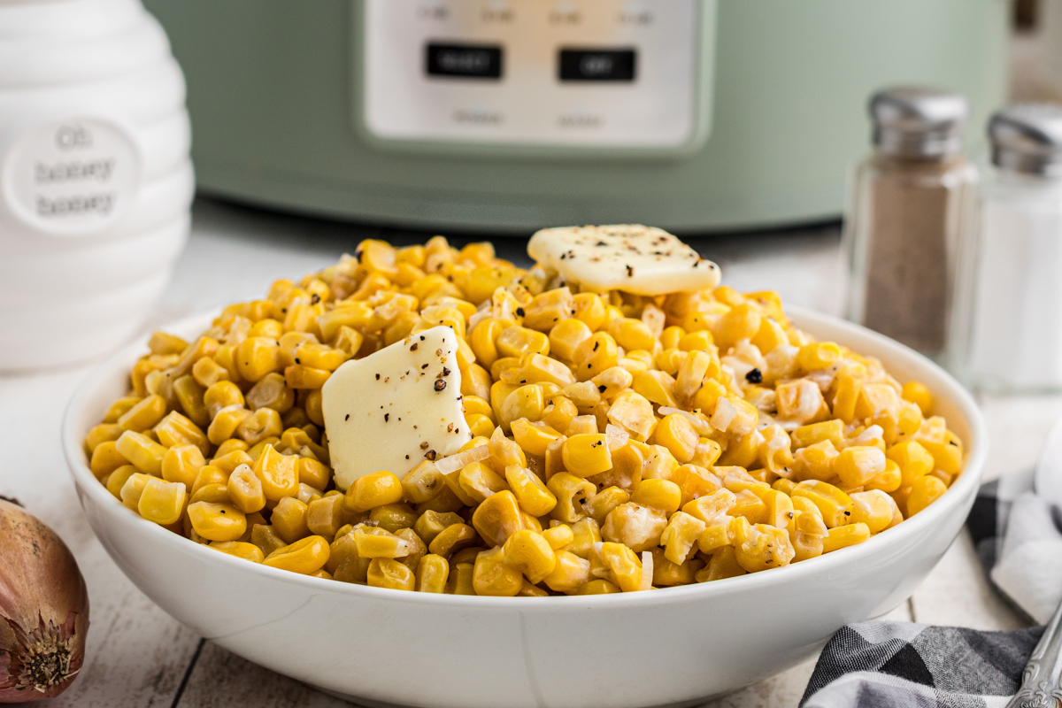 bowl of fried style corn in fron of a slow cooker.