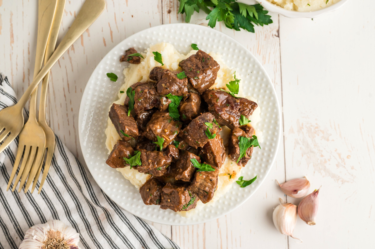 Plate of steak bites on mashed potatoes.