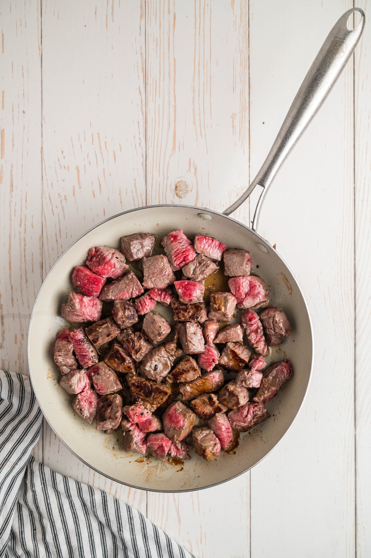cubed steak being browned in a skillet.