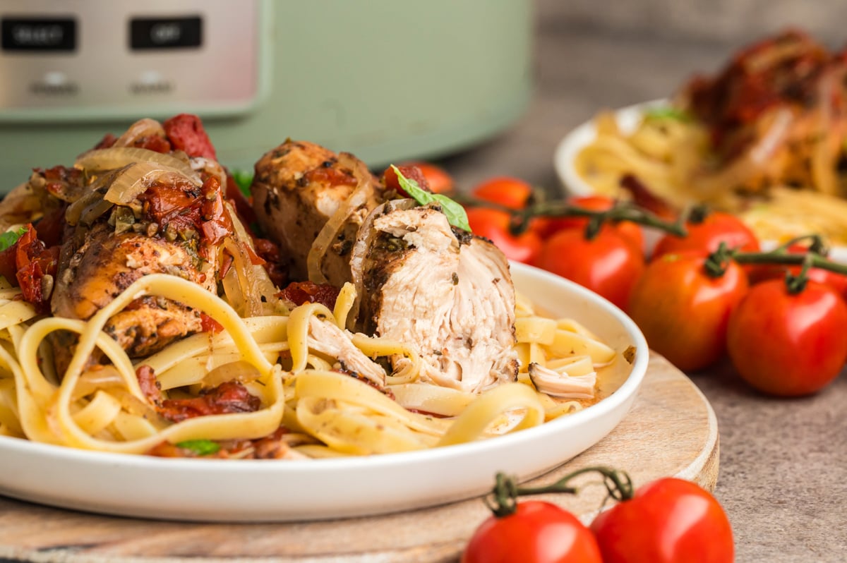 close up of balsamic chicken over noodles.