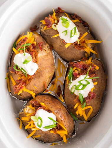 Cooked loaded baked potatoes in a crockpot.