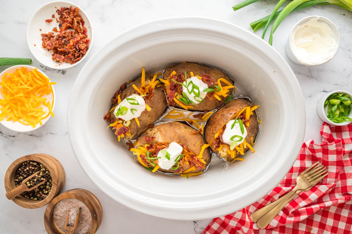 close up of baked potatoes with topping on the side.