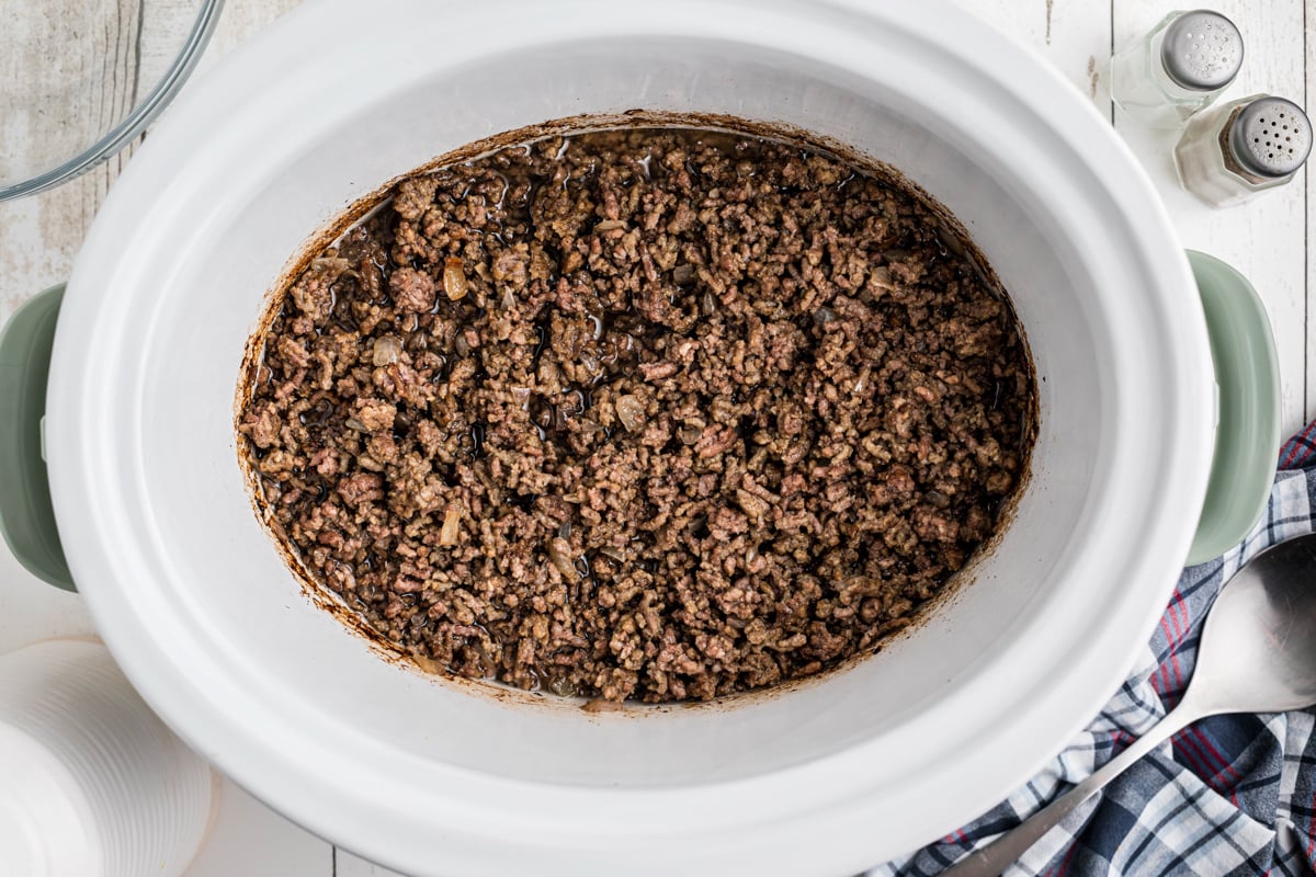 overhead shot of ground beef in a slow cooker.