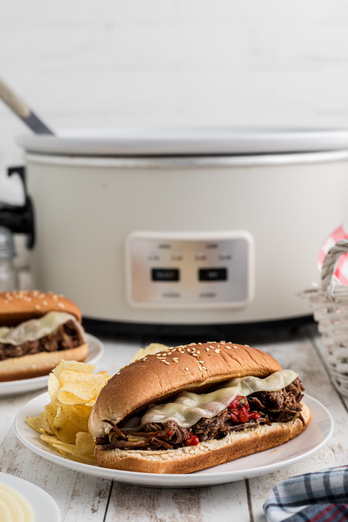 italian beef sandwich in front of a slow cooker.