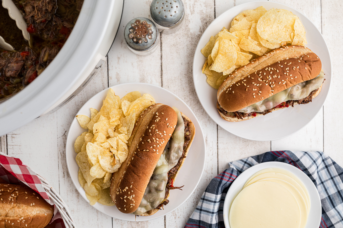 overhead shot of italian beef sandwiches with chips.